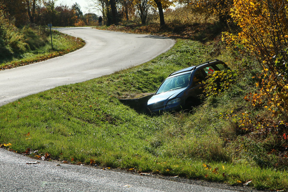 car in deep ditch at side of road